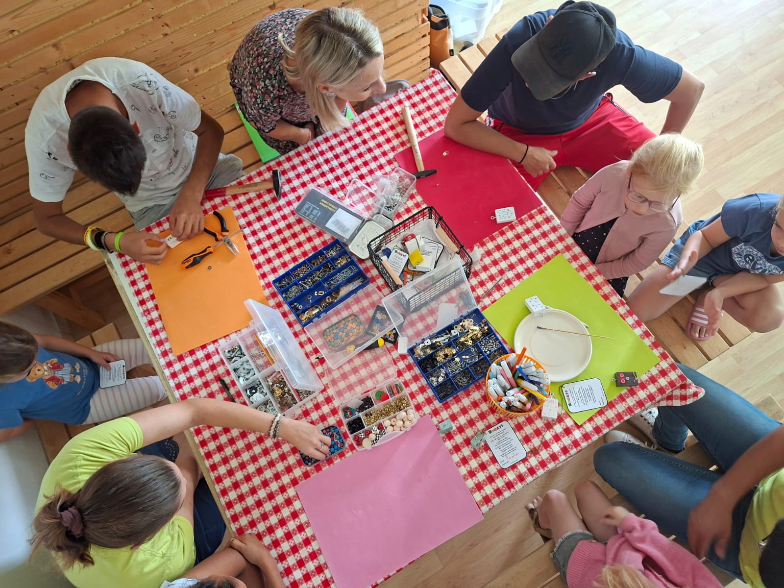 Ragazzi e volontari riuniti attorno a un tavolo da laboratorio creativo nella sede Eliodoro